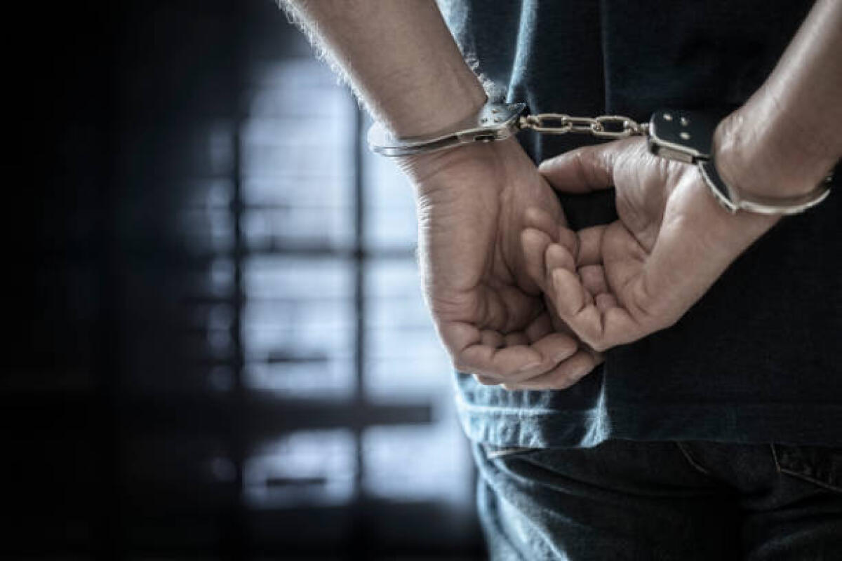 Ricercato per rapina a mano armata, latitante di San Severo si costituisce dopo due anni - Arrested man in handcuffs with handcuffed hands behind back in prison