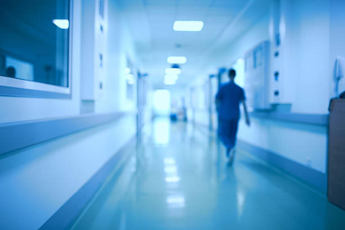 Intelligenza artificiale in ospedale: un’opportunità da sfruttare? - Hospital corridor and doctor as a blurred defocused background