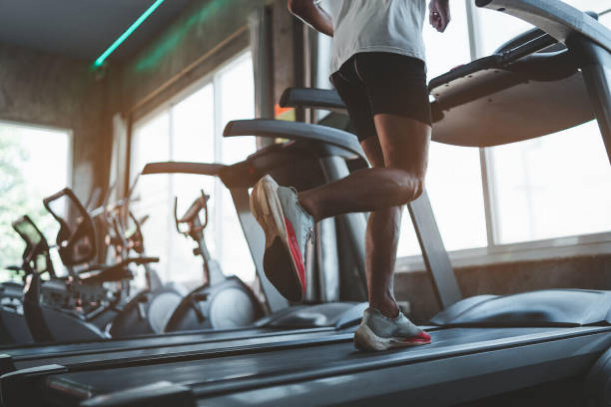 I trend del Fitness 2026: in che direzione sta andando il mondo dell’allenamento? - Close up of feet, sportman runner running on treadmill in fitness club. Cardio workout. Healthy lifestyle, guy training in gym. Sport running concept